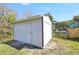 View of a white outbuilding in the backyard surrounded by grass at 4429 Rossmore Dr, Orlando, FL 32810