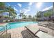 Community pool with sun loungers surrounded by lush landscaping and clear blue skies at 450 Windmill Palm Cir, Altamonte Springs, FL 32701