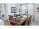 Elegant dining area with a long wooden table set for a meal and large windows for natural light at 4507 Monado Dr, Kissimmee, FL 34746