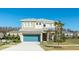 Two-story home featuring a blue garage door, a neutral-colored facade, and well-maintained landscaping at 4507 Monado Dr, Kissimmee, FL 34746