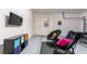 Finished garage with black seating, TV, colorful storage and a dart board for entertainment at 4507 Monado Dr, Kissimmee, FL 34746
