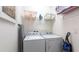 Functional laundry room with washer, dryer, shelving, and storage for cleaning supplies at 4507 Monado Dr, Kissimmee, FL 34746