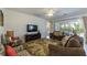 Comfortable living room with neutral toned walls, TV, couches, and sliding glass doors to the backyard at 4507 Monado Dr, Kissimmee, FL 34746