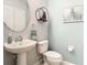Stylish powder room features a pedestal sink, modern mirror, and light blue walls at 4952 Matteo Trl, Orlando, FL 32839