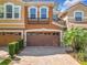 Charming townhome with a two-car garage, brick paver driveway, and beautifully landscaped front yard at 4952 Matteo Trl, Orlando, FL 32839