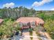 Beautiful shot of the exterior elevation with an orange tile roof, surrounded by lush trees, and well manicured lawn at 4952 Matteo Trl, Orlando, FL 32839