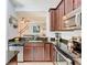 Well-lit kitchen boasts stainless steel appliances, granite countertops, and dark wood cabinetry at 4952 Matteo Trl, Orlando, FL 32839