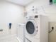Efficient laundry room with a washer, dryer, and practical shelving for storage at 4952 Matteo Trl, Orlando, FL 32839