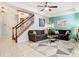 Inviting living room features neutral tones, ceiling fan and staircase access at 4952 Matteo Trl, Orlando, FL 32839