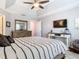 Comfortable main bedroom features a tray ceiling, large window, and hardwood floors at 4952 Matteo Trl, Orlando, FL 32839