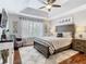 Spacious main bedroom with a tray ceiling, ceiling fan, and a large window at 4952 Matteo Trl, Orlando, FL 32839