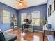 Office with hardwood floors, blue walls, two windows, and an oversized fan at 4952 Matteo Trl, Orlando, FL 32839