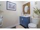 Charming powder room features blue vanity, ornate mirror, framed art, and a neutral color scheme at 500 Forest Lake Dr, Altamonte Springs, FL 32714
