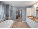 Relaxing bathroom featuring a soaking tub, walk-in shower, and a dual sink vanity with granite counters at 500 Forest Lake Dr, Altamonte Springs, FL 32714