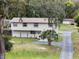Two-story home with neutral siding, complemented by a landscaped front yard and a long driveway to a detached garage at 500 Forest Lake Dr, Altamonte Springs, FL 32714