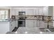 Modern kitchen with gray cabinetry, stainless steel appliances, granite countertops, and stylish backsplash at 500 Forest Lake Dr, Altamonte Springs, FL 32714