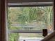 A charming lake view seen through a window with light drapes and exterior foliage at 500 Forest Lake Dr, Altamonte Springs, FL 32714