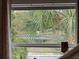Window view showcasing lush greenery and a tranquil pond, creating a serene and private setting at 500 Forest Lake Dr, Altamonte Springs, FL 32714
