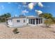Exterior elevation of a charming single-story home with a gravel yard and an enclosed lanai at 519 Tivoli Park Dr, Davenport, FL 33897