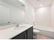 Bathroom with a large vanity, single sink, a bathtub shower combo, white tile, and quartz countertops at 5719 Cattle Ranch Dr, St Cloud, FL 34771