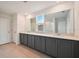Modern bathroom with gray cabinets, double sinks, tile floors and lots of natural light at 5719 Cattle Ranch Dr, St Cloud, FL 34771
