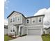 Well-designed two-story home showcasing a gray color scheme, attached garage, and a neatly kept lawn at 5719 Cattle Ranch Dr, St Cloud, FL 34771