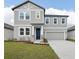 Charming two-story home featuring a gray exterior, well-manicured lawn, and attached two-car garage at 5719 Cattle Ranch Dr, St Cloud, FL 34771