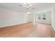 Spacious living room with hardwood floors, a modern chandelier, and ample natural light from the windows at 5719 Cattle Ranch Dr, St Cloud, FL 34771