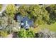 Aerial view showcases the home with a dark roof surrounded by trees at 5850 Sheryl Anita St, Oviedo, FL 32765