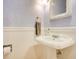 Powder room features a white pedestal sink, decorative mirror, and wainscoting at 5850 Sheryl Anita St, Oviedo, FL 32765