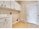 Bright laundry room with hardwood floors, overhead cabinets, and washer/dryer hookups at 5850 Sheryl Anita St, Oviedo, FL 32765