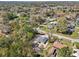 A high-angle shot showing a house set among lush trees with neighboring homes and a nearby road at 6551 Hemlock Rd, Ocala, FL 34472