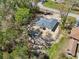 An aerial view of a single-Gathering home still under construction, with surrounding trees and a neighboring house at 6551 Hemlock Rd, Ocala, FL 34472