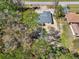 An aerial view of the new house, showing tree coverage and nearby residential properties, including an inground pool at 6551 Hemlock Rd, Ocala, FL 34472