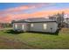 Home's backyard with green grass and colorful sky at 6551 Hemlock Rd, Ocala, FL 34472