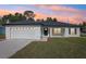 Charming one-story home featuring a two-car garage, minimalist landscaping, and a welcoming front porch at 6551 Hemlock Rd, Ocala, FL 34472