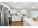 Modern kitchen featuring stainless steel appliances, white cabinets, quartz countertops and gold hardware at 6551 Hemlock Rd, Ocala, FL 34472