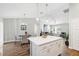 Open-concept kitchen featuring a large island with white cabinets and gold hardware and a dining area at 6551 Hemlock Rd, Ocala, FL 34472