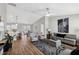 Bright living room featuring hardwood floors, gray furniture, modern lighting and a zebra-themed art piece at 6551 Hemlock Rd, Ocala, FL 34472