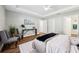Spacious main bedroom with a tray ceiling, two chairs, modern decor and ample natural light at 6551 Hemlock Rd, Ocala, FL 34472