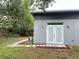Exterior view showcasing the backyard with stone tile path and white double doors at 714 Kankakee Ln, Orlando, FL 32807