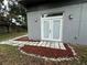 This showcases an exterior view of the backyard, focusing on the stone tile pathway and double doors at 714 Kankakee Ln, Orlando, FL 32807