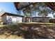 Spacious backyard with mature tree offering shade near a gray home at 714 Kankakee Ln, Orlando, FL 32807