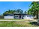 Well-maintained single-story home with gray exterior, lush green lawn, and attached garage at 714 Kankakee Ln, Orlando, FL 32807
