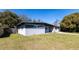 An angled view of a well-maintained single-story home with a gray exterior and a green lawn at 714 Kankakee Ln, Orlando, FL 32807