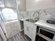 Laundry room showcasing a sink with marble-look backsplash and a microwave at 714 Kankakee Ln, Orlando, FL 32807
