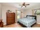 Comfortable bedroom featuring natural light, a ceiling fan, and wood-look tile floors at 75 Chaney Dr, Casselberry, FL 32707