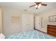 Bright bedroom with wood-look tile floor, ceiling fan, closet, and neutral wall colors at 75 Chaney Dr, Casselberry, FL 32707
