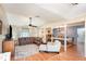 Open concept living room features a leather sofa, wood floors and a ceiling fan enhancing the spacious interior at 75 Chaney Dr, Casselberry, FL 32707