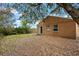 View of the backyard, the home's exterior, patio, and a lawn covered in leaves at 8549 Rainbow Ave, Orlando, FL 32825